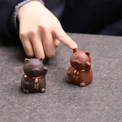 Chat Porte Bonheur Chinois en Céramique Statuette Maneki Neko marron foncé marron clair sur une table kaosix